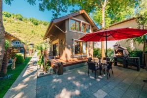 a house with a patio with a table and an umbrella at antik river house in Sile