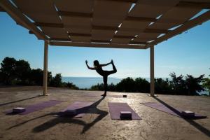 a woman standing in a yoga pose in front of the ocean at Extravagant Zante Villa Villa Crystal Great Sea Views 3 Bedrooms Agios Nikolaos in Koríthion