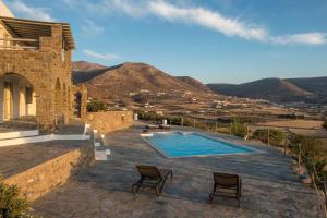 una villa con piscina e montagne sullo sfondo di Platinum Paros Villa Ocyrhoe Iii Villa 4 Bedrooms Private Pool & Fantastic Sea Views Parikia a Paroikia