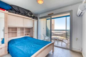 une chambre avec un lit et un balcon dans l'établissement Sur les hauteurs du Fidji, à La Grande Motte