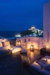 a patio with couches and a view of the ocean at night at Elegant Astypalaia Villa Villa Ble Air Conditioning Hot Tub in Astypalaia Town