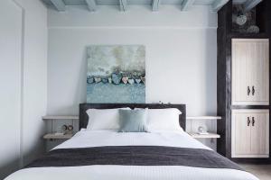a bedroom with a bed and a painting on the wall at Elegant Astypalaia Villa Villa Ble Air Conditioning Hot Tub in Astypalaia Town