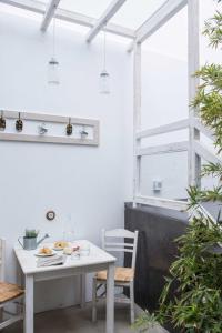 a white table and chairs in a room with a window at Elegant Astypalaia Villa Villa Ble Air Conditioning Hot Tub in Astypalaia Town