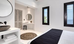 ein weißes Schlafzimmer mit Waschbecken und Spiegel in der Unterkunft Dazzling Mykonos Villa Villa Lvellie 6 Bedrooms Unique Aegean Sea Views in Psarrou + 26 Fotos