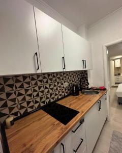 a kitchen with white cabinets and a wooden counter top at Mira Apartmani in Mostar +29 photos