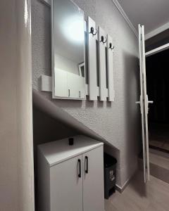 a bathroom with a white cabinet and a staircase at Mira Apartmani in Mostar