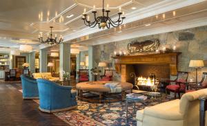 a living room with a fireplace and blue chairs at Woodstock Inn & Resort in Woodstock