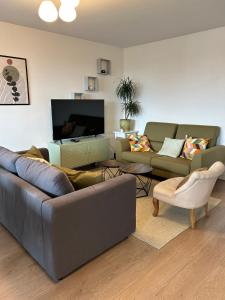 a living room with couches and a flat screen tv at Agréable 3 pièces - 8P - Parking - Séjour idéal Paris Proche Gare in La Courneuve