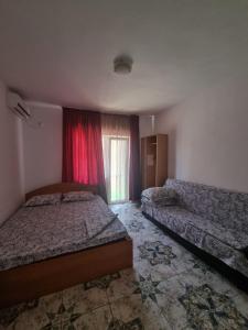une chambre avec deux lits et une fenêtre dans l'établissement Casa Natalia, à Eforie Nord