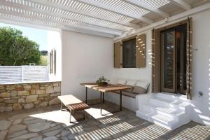 a patio with a table and a bench at Executive Paros Villa Villa Aiolos Private Pool & Jacuzzi Villa Kostos Damouli in Kampos Paros