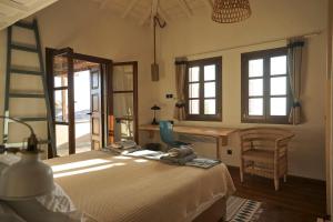 ein Schlafzimmer mit einem Bett und einem Stuhl und Fenstern in der Unterkunft Great Pelion Villa Villa Iris 4 Bedrooms Private Pool in Pilion + 30 Fotos