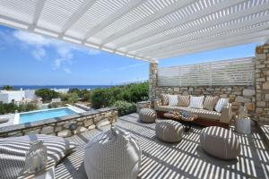 eine Terrasse mit einer weißen Pergola neben einem Pool in der Unterkunft Executive Paros Villa 4 Bedrooms Villa Island Spirit Amazing Sea Views in Kampos Paros