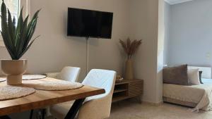 a dining room with a table and a tv on the wall at Diamond Corfu Viros Suite by CorfuEscapes in Bastoúnion