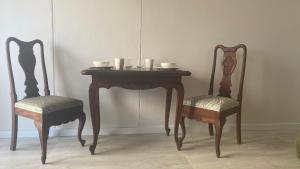 a table with two chairs and a table with bowls on it at Witsand Holiday Flat in Witsand