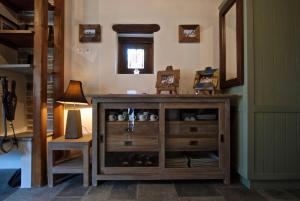 ein Holzschrank in einem Raum mit einer Lampe und einem Stuhl in der Unterkunft Great Pelion Villa Villa Stone House 2 Bedrooms Sea View in Pilion