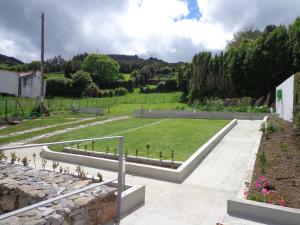 a garden with a lawn and a stone wall at Casa do Simão in Nordeste