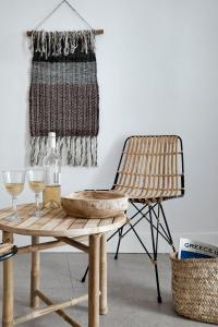 Luxury Santorini Villa Superior Cave Villa Outdoor Hot Tub في أويا: كرسي ratan وطاولة في غرفة