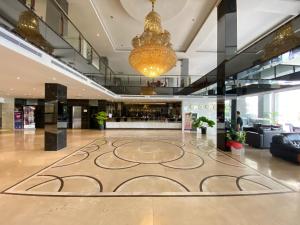 a lobby with a large rug in the middle of a building at Alltrue Sydney Hotel Batam Center in Batam Center