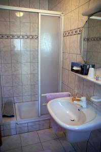 a bathroom with a tub and a sink and a shower at Hotel Restaurant Bieberstuben in Menden