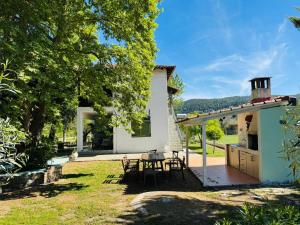 a patio with a table and chairs in a yard at La maison des vacances in Vourvourou