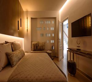 a bedroom with a large bed and a television at Luxury Santorini Villa 4 Bedroom Villa Secluded Location & Private Pool Megalochori in Megalokhori