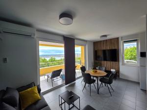 ein Wohnzimmer mit einer Couch und einem Tisch und Stühlen in der Unterkunft Apartment Panorama in Jadranovo