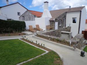 a house with a stone fireplace in the yard at Casa do Simão in Nordeste