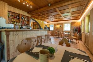 a room with a bar and some tables and chairs at Dolomites Hotel La Meridiana in Moena