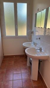 a bathroom with two sinks and a window at Gîte U Saltu in Solaro