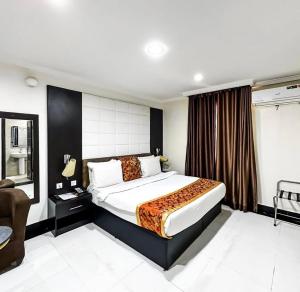 ein Schlafzimmer mit einem großen Bett in einem Zimmer in der Unterkunft Pasadena hotel and suites in Lagos