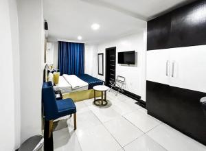 ein Hotelzimmer mit einem Schlafzimmer mit einem Bett und einem TV in der Unterkunft Pasadena hotel and suites in Lagos