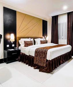 ein Schlafzimmer mit einem großen Bett mit großem Kopfteil in der Unterkunft Pasadena hotel and suites in Lagos