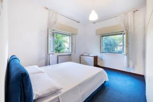 a bedroom with a white bed and two windows at Trilocale Abruzzi 6 Riccione in Riccione