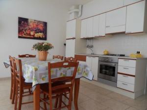 a kitchen with a table and chairs and a kitchen with white cabinets at La Veranda in Margherita di Savoia