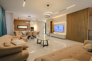 a living room with couches and a table and a television at SanPietro Vacation Apartments in Durrës