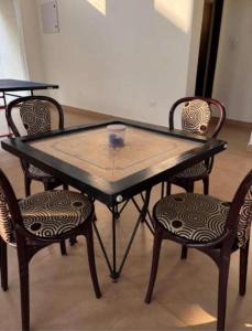 a ping pong table with four chairs around it at Mercury Duplex villa in Covelong