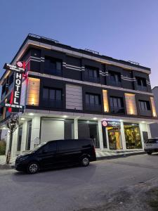 een zwart busje geparkeerd voor een gebouw bij Fourpoints Airport Hotel in Arnavutköy