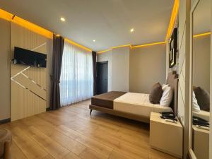 een slaapkamer met een bed en een tv aan de muur bij Fourpoints Airport Hotel in Arnavutköy
