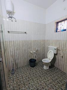 a bathroom with a toilet and a shower in it at Gods Gift Homestay James Inn in Kozhikode +20 photos