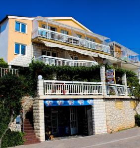 a building with a balcony on top of it at Apartmani Jelena in Neum