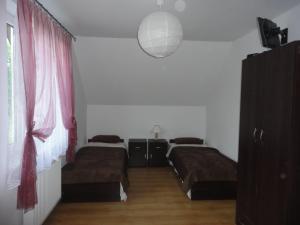 1 dormitorio con 2 camas y luz colgante en Nocleg nad Jeziorem Hańcza - B.Danowska en Przełomka