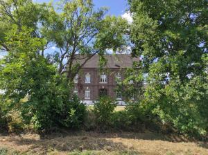 a large brick house with trees in front of it at Gartenblick im Gutshaus - Ferienwohnung in Kevelaer