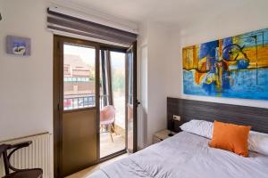 a bedroom with a bed and a large painting on the wall at Hotel Villamayor by gaiarooms in Villamayor