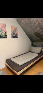a bed in a room with paintings on the wall at Casa Frida- Charmante Wohnung mit Parkplatz nähe Bayreuth in Creez