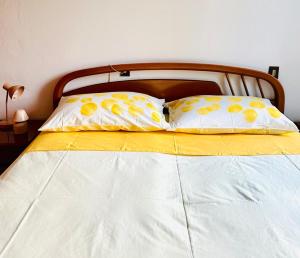 a bed with two yellow and white pillows on it at Ampio, Luminoso, Centro Bassano in Bassano del Grappa +22 photos