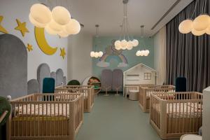 a nursery with wooden cribs in a room with a crib at Titanic Deluxe Lara in Lara