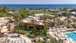 an aerial view of a resort with a pool and the ocean at Titanic Deluxe Lara in Lara