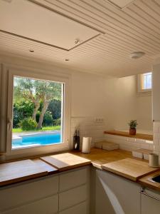 a kitchen with a large window and a kitchen counter at Villa Labenne Ocean - piscine, 500 mètres de la plage in Labenne