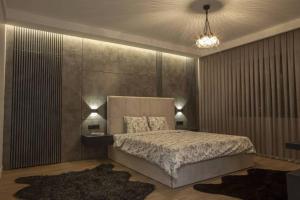 a bedroom with a large bed and two lamps at Aurora suit in Podgorica