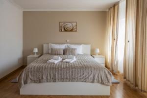 a bedroom with a large bed with two towels on it at Residencial Princesa do Ave in Vila do Conde +71 photos